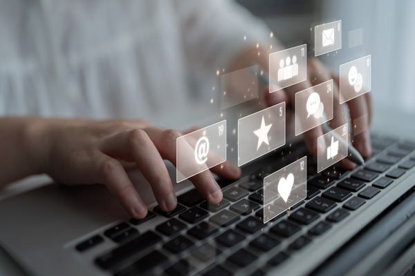 Person using a laptop with social media icons overlayed on the screen
